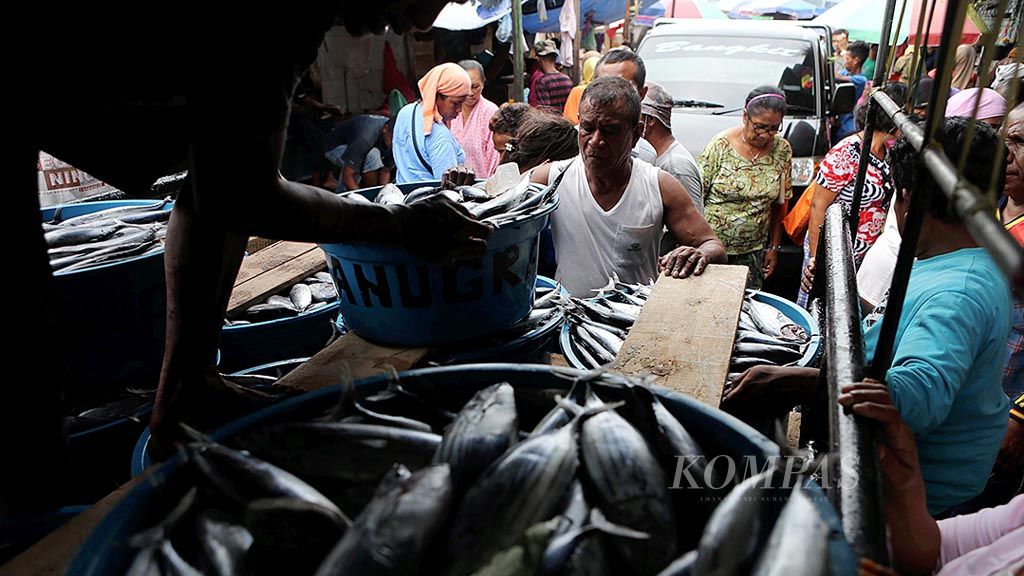 Pekerja menurunkan ikan dari kapal di Pasar Ikan Mardika, Kota Ambon, Maluku, Jumat (10/2). Saat ini, harga satu loyang ikan layang dan tongkol atau sekitar 30 kilogram seharga Rp 450.000. 