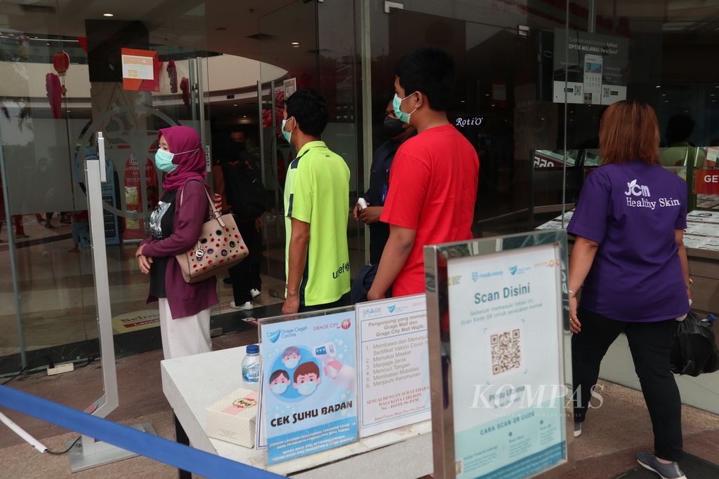 Pengunjung menjalani pemeriksaan suhu tubuh sebelum memasuki Grage City Mall, Kota Cirebon, Jawa Barat, Minggu (13/2/2022). 