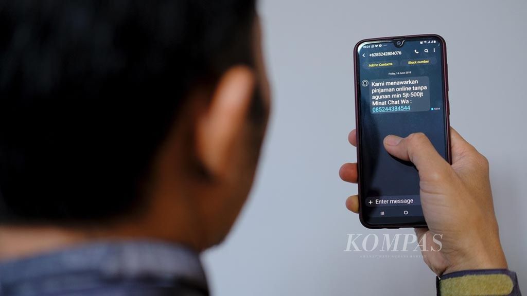 Warga memperlihatkan salah satu SMS yang menawarkan pinjaman berbasis daring, di Jakarta, Minggu (16/6/2019).