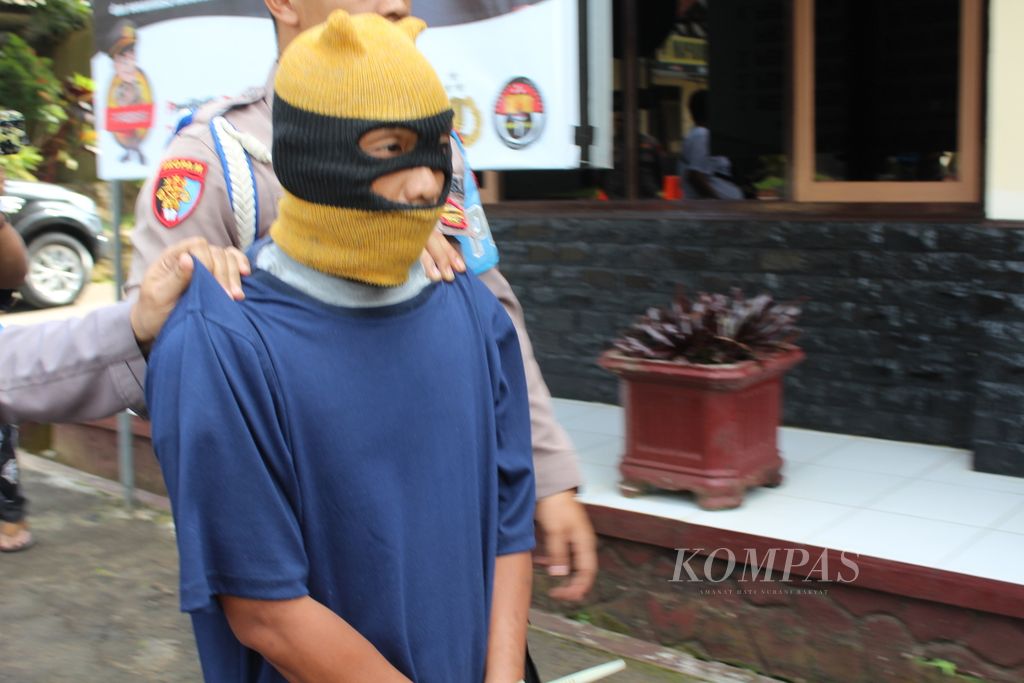 Polisi membawa AW, tersangka kasus pencabulan, di Kepolisian Resor Kuningan, Kabupaten Kuningan, Jawa Barat, Jumat (14/7/2023). AW diduga kuat mencabuli dua anak tirinya. Kini, tersangka terancam maksimal 20 tahun penjara.