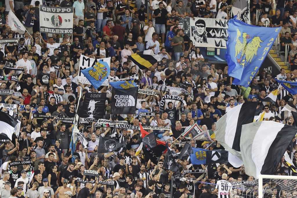 Para pendukung Udinese mengibarkan bendera saat menyaksikan laga Liga Italia antara Udinese dan AS Roma di Stadion Friuli, Udine, Italia, Senin (5/9/2022) dini hari WIB.