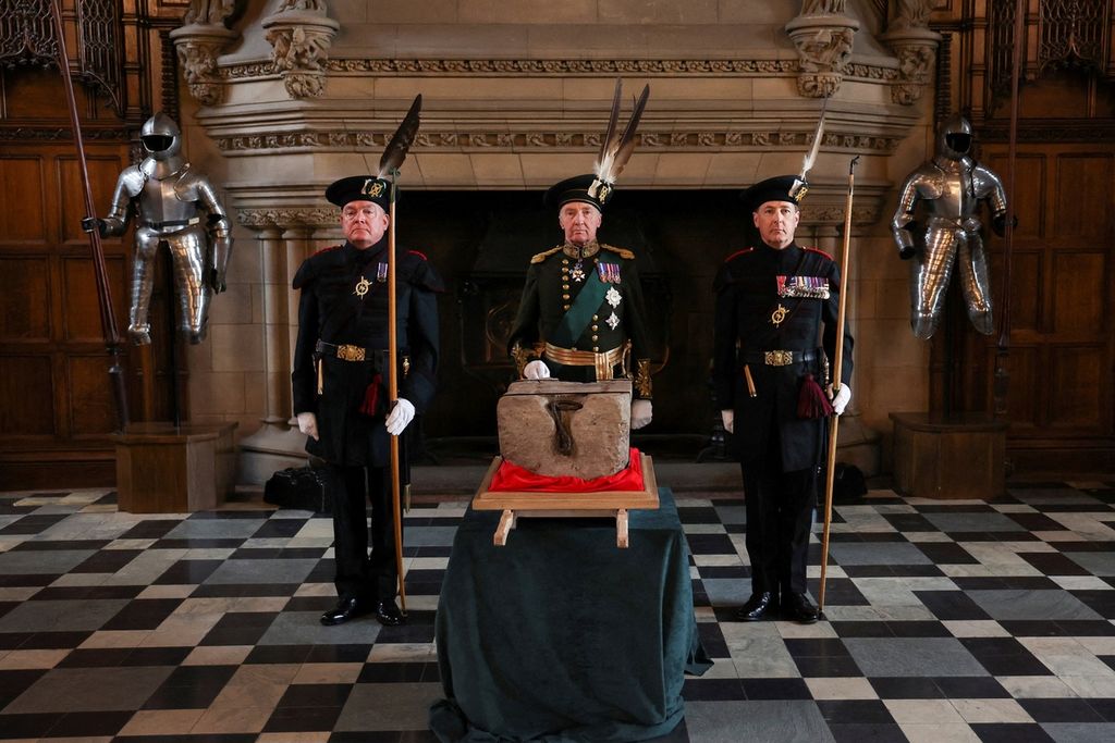 Duke of Buccleuch Richard Scott (tengah) diapit oleh dua anggota The Royal Company of Archers, berdiri di samping Batu Takdir selama upacara khusus di Kastil Edinburgh pada 27 April 2023 sebelum dipindahkan ke Westminster Abbey untuk Penobatan Raja Inggris Charles III. 