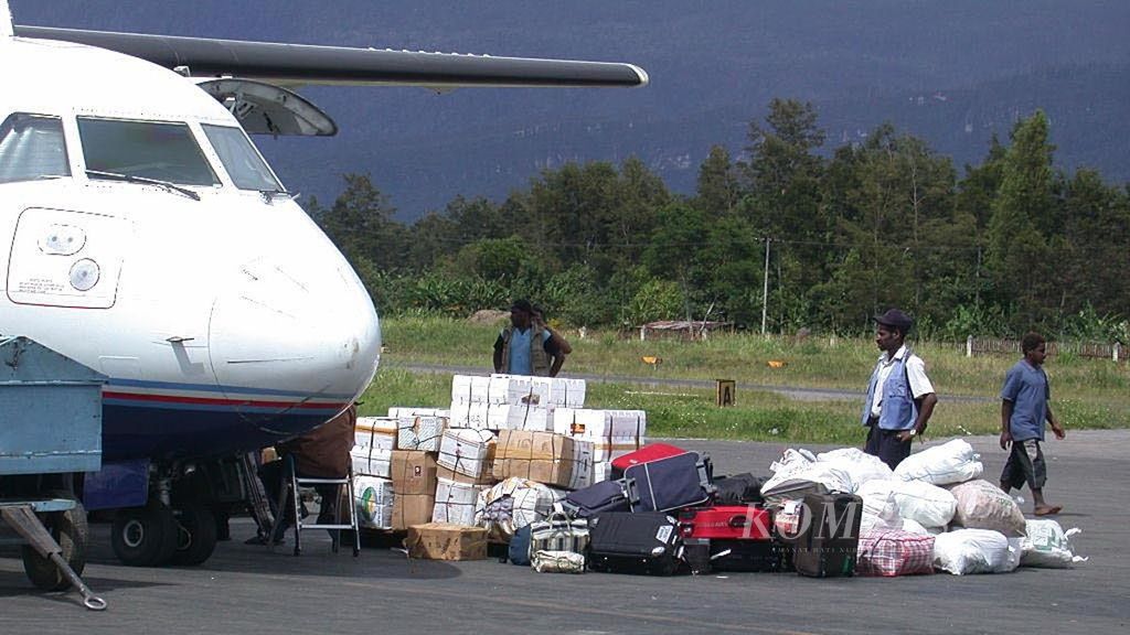 Sejumlah barang kebutuhan masyarakat diturunkan dari pesawat Trigana Air yang baru datang dari Jayapura di Bandara Wamena, Kabupaten Jayawijaya, Papua, Selasa (20/12/2017).