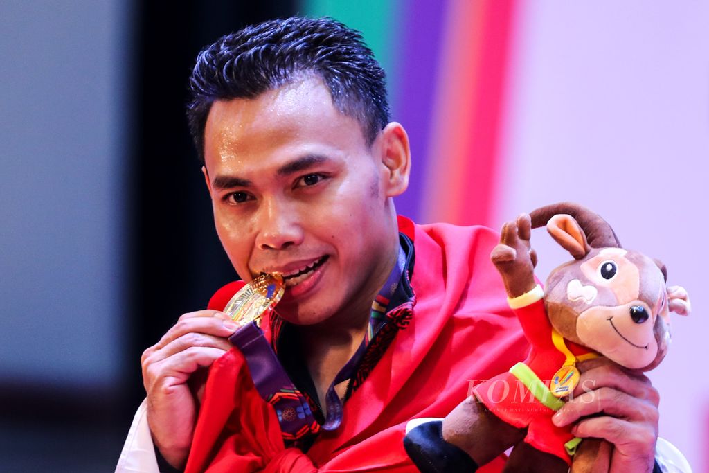 Lifter Indonesia, Eko Yuli Irawan, bersama medali emas yang diraihnya dalam nomor 61 kilogram putra cabang angkat besi pada SEA Games Vietnam 2021 di Hanoi Training Center, Hanoi, Vietnam, Jumat (20/5/2022). 