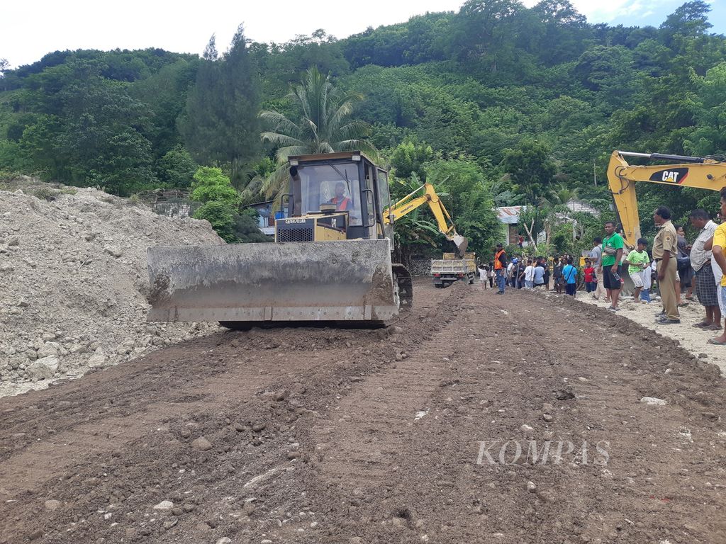 <i>Loader</i> meratakan jalan darurat di lokasi longsor di Kelurahan Takari, Kabupaten Kupang, Nusa Tenggara Timur, pada Senin (20/2/2023). Dua <i>loader</i> dan tujuh ekskavator dikerahkan ke lokasi itu.