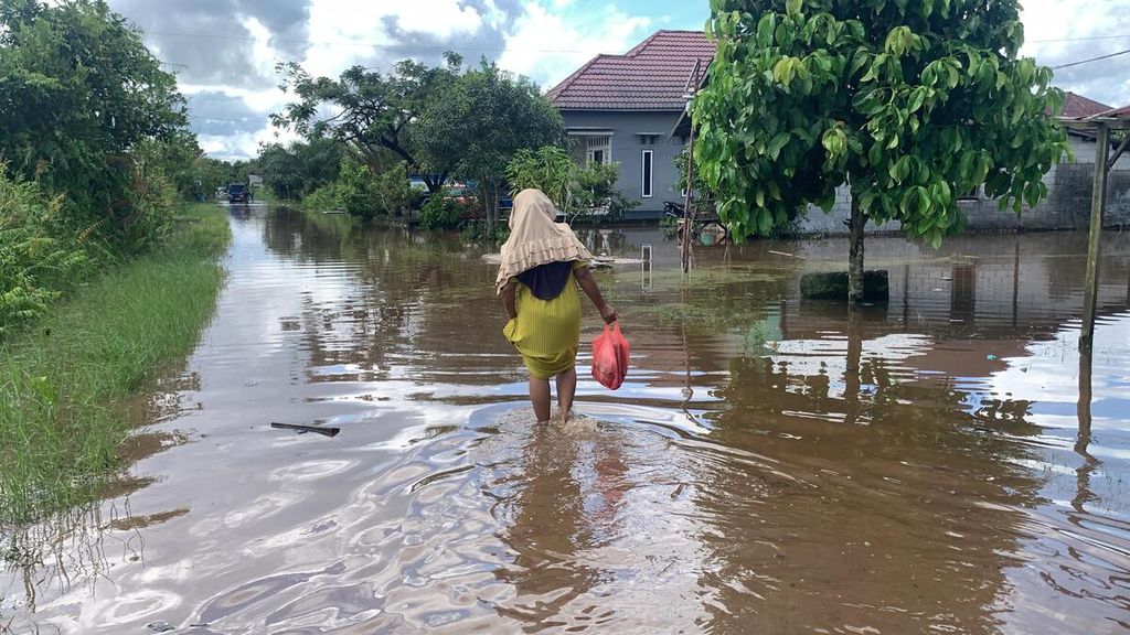 Warga berjalan melintasi banjir di Sampit, Kabupaten Kotawaringin Timur, Kalimantan Tengah, Kamis (2/5/2024).