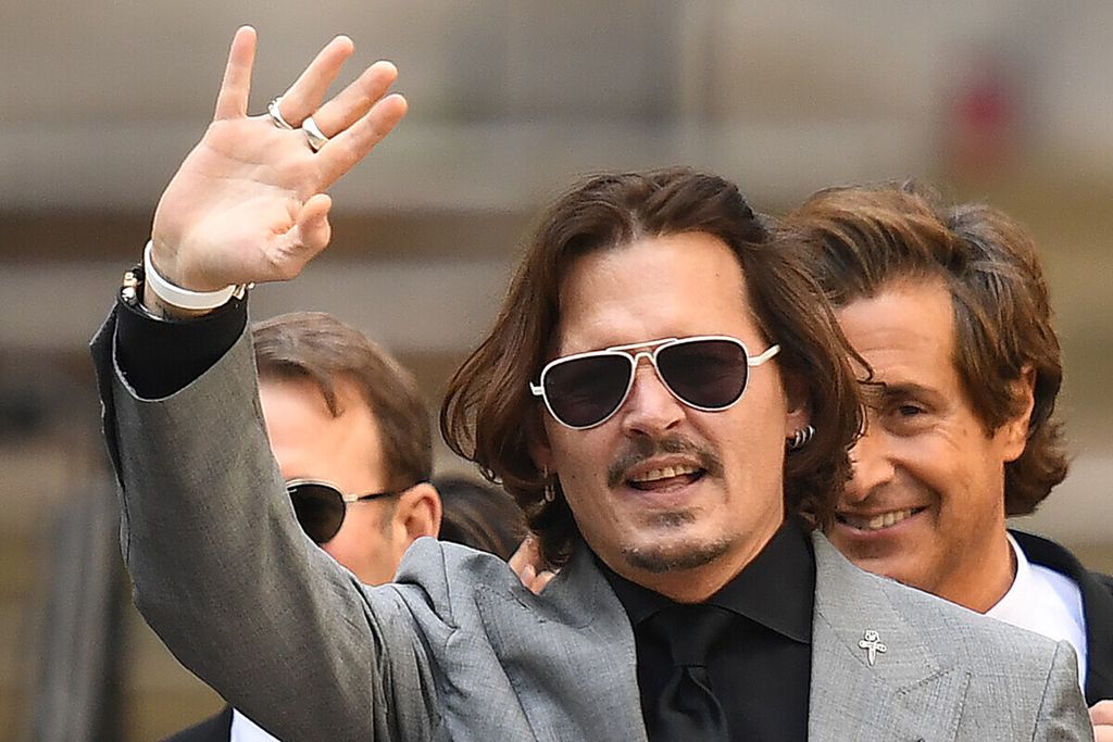Aktor Amerika Serikat, Johnny Depp, melambaikan tangan ketika meninggalkan Pengadilan Tinggi London setelah hari terakhir persidangannya melawan News Group Newspapers (NGN) di London, Inggris, pada 28 Juli 2020. Johnny Depp menuntut tabloid Inggris, <i>The Sun</i>, atas tuduhan ia memukul mantan istrinya, aktris Amber Heard. Depp menolak tuduhan telah berulang kali menyakiti aktris itu dalam waktu tiga tahun selama pernikahan yang berakhir dengan perceraian.