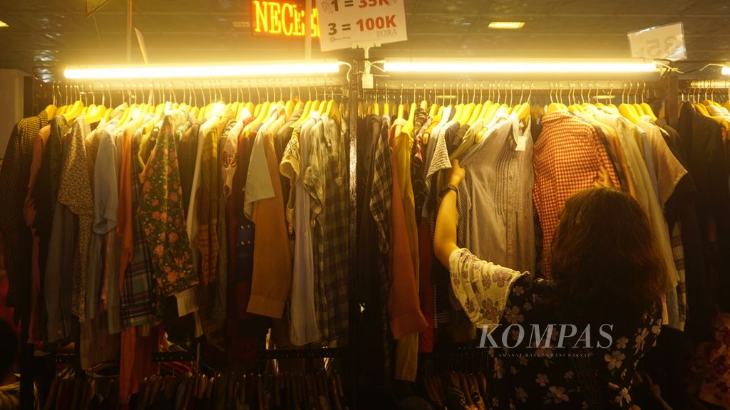 Pengunjung mencari pakaian bekas yang dijajakan dalam ajang lapak pakaian bekas bertajuk "Nglapak Day" di Kota Surakarta, Jawa Tengah, Minggu (5/6/2022).