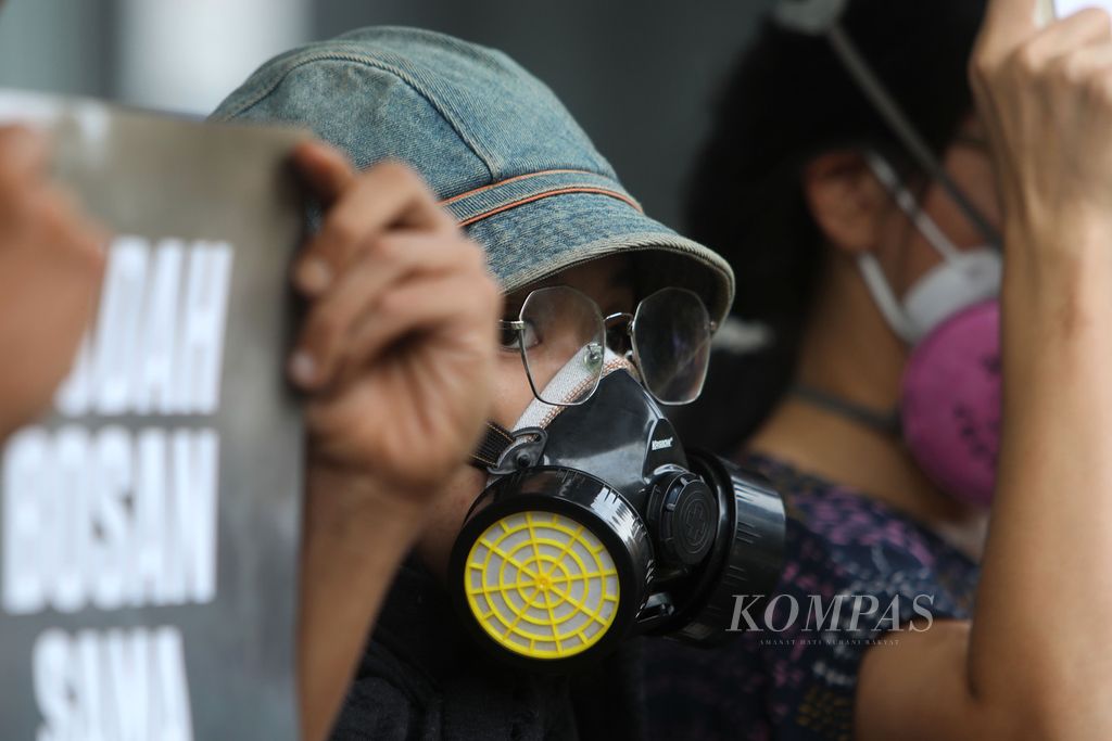 Aktivis lingkungan yang tergabung dalam Koalisi Ibukota mengenakan masker sebagai simbol buruknya udara di Jakarta saat aksi di Pengadilan Negeri Jakarta Pusat, Jakarta, Senin (17/1/2022). 