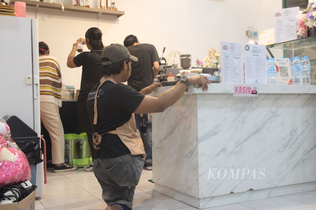 Untung (24) bersiap mengantarkan pesanan konsumen di Satu Per Dua Kopitiam, Kota Pontianak, Kalimantan Barat, Rabu (14/8/2024) malam.