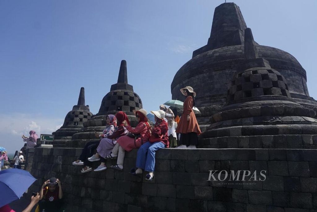 Rombongan pengunjung asyik berfoto di Candi Borobudur, Kabupaten Magelang, Jawa Tengah, Jumat (26/1/2020).