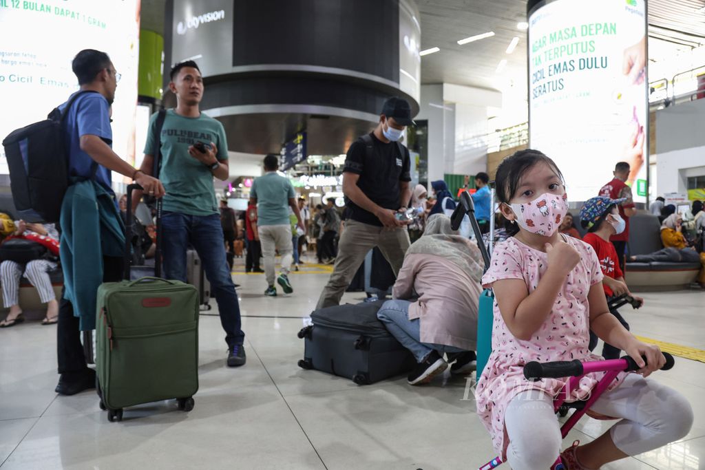 Seorang anak menunggu orangtuanya menyiapkan koper di Stasiun Gambir, Jakarta, Kamis (21/12/2023). Lebih dari 14.000 warga meninggalkan Jakarta melalui Stasiun Gambir pada 21 Desember 2023.