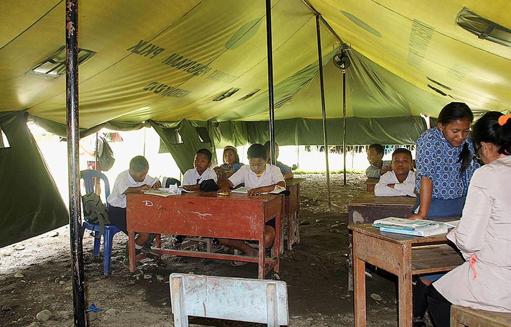 Para siswa kelas VII SMP Satu Atap Sedoa di Kecamatan Lore Utara, Kabupaten Poso, Sulawesi Tengah, belajar di tenda, seperti terlihat pada hari Kamis (14/9). Gedung sekolah mereka hancur akibat gempat bumi berkekuatan 6,6 skala Richter pada 29 Mei 2017.