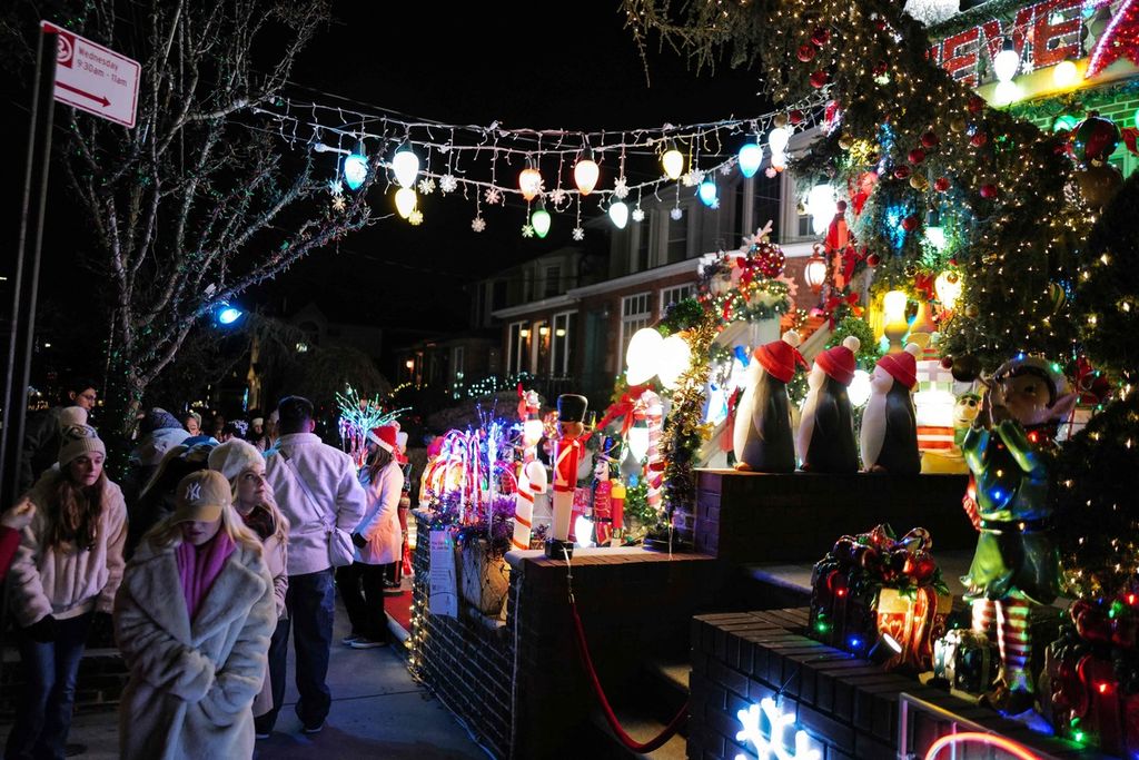 Orang-orang melihat rumah-rumah yang dihiasi dengan dekorasi dan lampu-lampu natal di kawasan Dyker Heights, Brooklyn, New York, AS, pada 20 Desember 2023. 