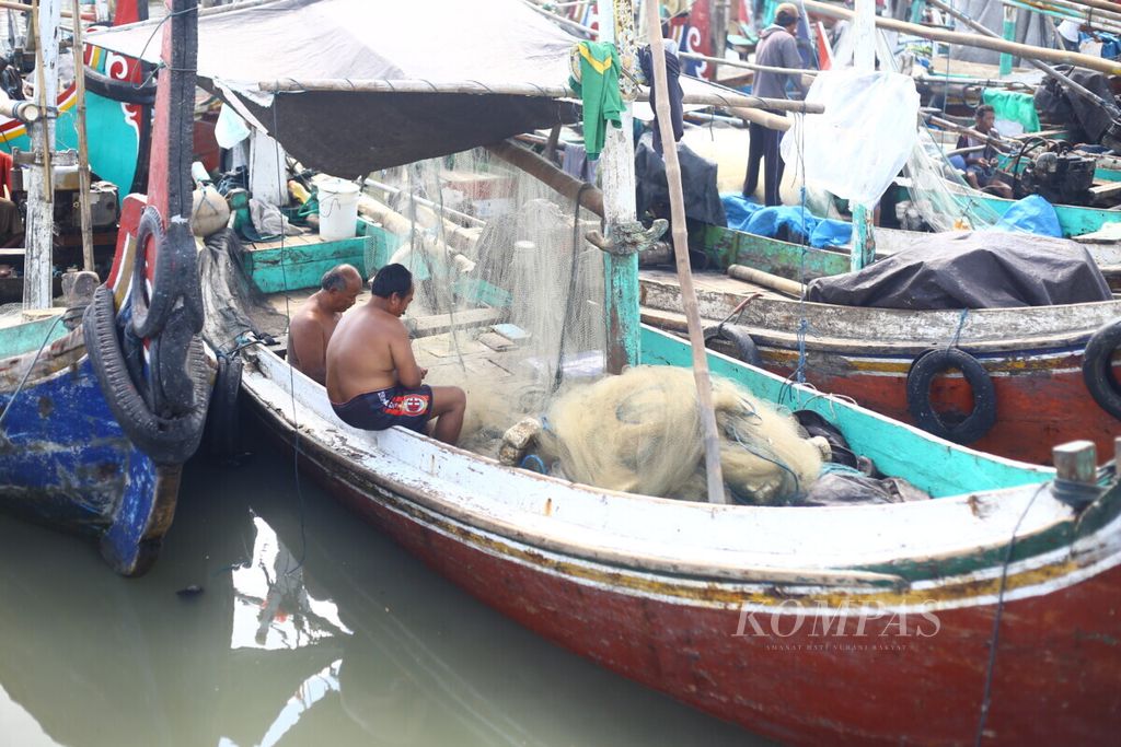 Sejumlah nelayan memperbaiki jaring di atas kapal yang tertambat di Pelabuhan Muncar, Banyuwangi, Jumat (2/10/2020). 
