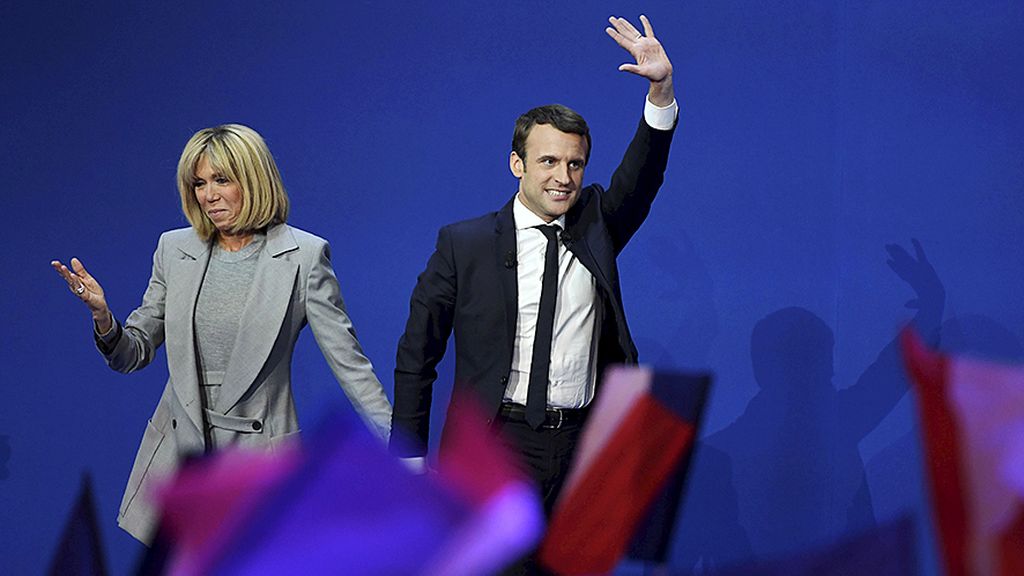 Calon presiden Perancis,  Emmanuel Macron (kanan), dan istrinya, Brigitte Trogneux,  bergandengan tangan di panggung di arena  Parc des Expositions, Paris, Perancis, 23 April lalu, seusai putaran pertama pemilu Perancis. Selain menjadi istri, Brigitte juga merupakan salah satu penasihat kepercayaan Macron.
