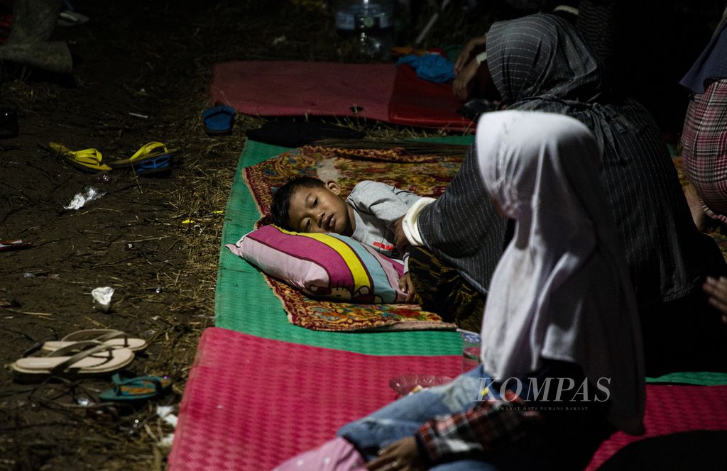 Seorang anak berbaring di tenda pengungsi korban gempa bumi di Desa Ciputri, Kecamatan Pacet, Kabupaten Cianjur, Jawa Barat, Kamis (24/11/2022) malam. 