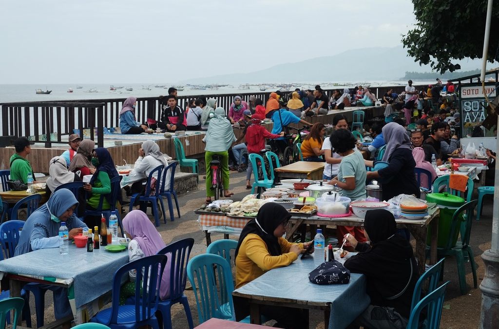 Suasana di Pantai Ampenan, Kota Mataram, NTB, yang dipadati pengunjung, Minggu (19/7/2020) pagi. Lemahnya kontrol dari pemerintah daerah atau pihak terkait lain membuat sebagian besar pengunjung pantai itu, termasuk pedagang, tidak disiplin menerapkan protokol kesehatan. Hal itu mengkhawatirkan mengingat Kota Mataram masih berada dalam zona merah penyebaran Covid-19.