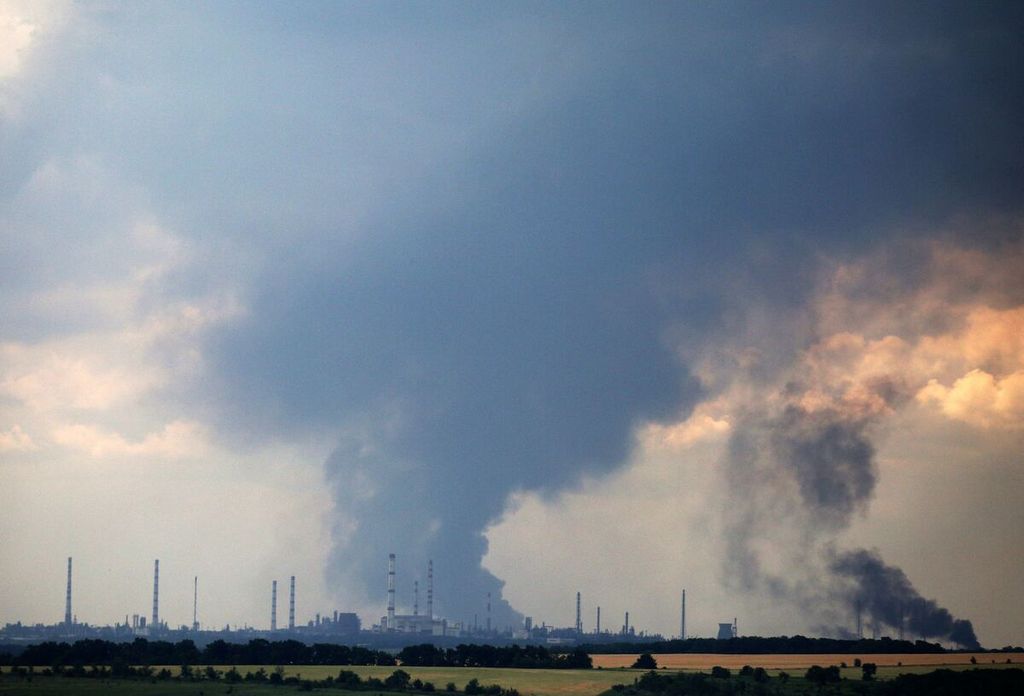 Asap mengepul di atas kilang pengolahan minyak di luar kota Lysychansk, wilayah Luhansk, Ukraina timur, 23 Juni 2022, saat berlangsung invasi militer Rusia ke Ukraina. 