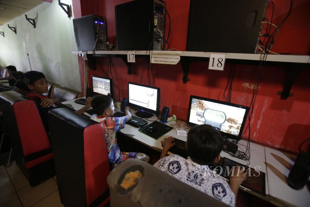 Anak-anak bermain <i>game online</i> di Warnet Fibernet Easy Cam di kawasan Kemandoran, Jakarta, Kamis (11/12/14). Warnet buka 24 jam, dengan konsumen terbanyak adalah pemain <i>game online,</i> mulai dari usia anak hingga dewasa. 