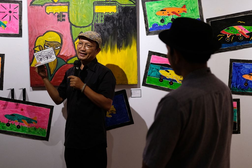 Nawa Tunggal (kiri) menceritakan di balik terciptanya lukisan yang dipamerkan di Bentara Budaya Jakarta, Palmerah, Kota Jakarta, Rabu (12/10/2022). 