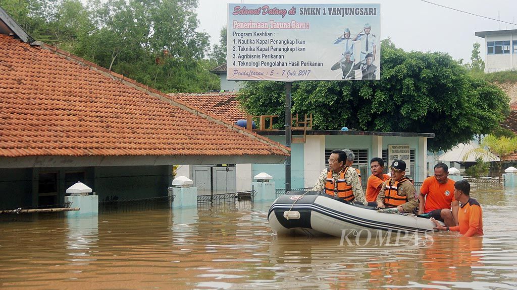 Gubernur Daerah Istimewa Yogyakarta (DIY) Sultan Hamengku Buwono X (kiri) beserta sejumlah pejabat memantau banjir di sekitar SMK Negeri 1 Tanjungsari, Kabupaten Gunung Kidul, DIY, Rabu (29/11).