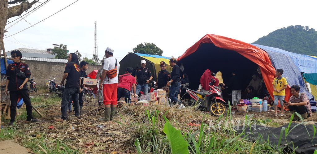 Sukarelawan mendistribusikan bantuan kepada pengungsi gempa di Desa Ciputri, Kecamatan Pacet, Kabupaten Cianjur, Jawa Barat, Minggu (27/11/2022).