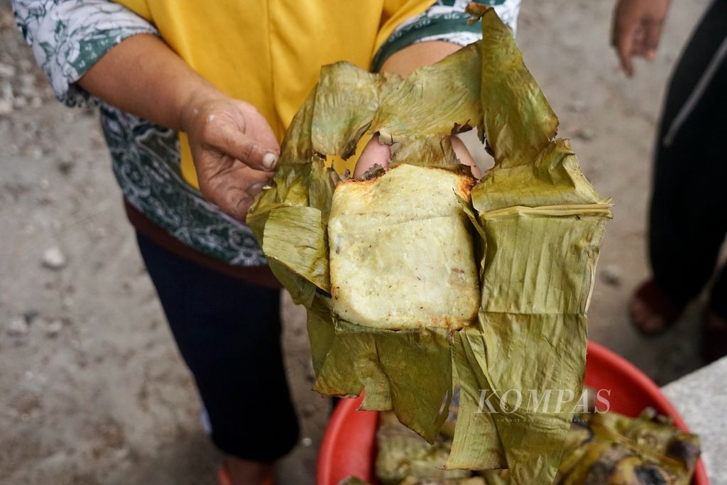 Wa Masrida (45) menunjukkan salah satu tombole dari olahan ubi, singkong, dan pisang, di Desa Pajam, Kaledupa Selatan, Wakatobi, Sulawesi Tenggara, Selasa (29/8/2023). Tombole, adalah hasil olahan pangan lokal dengan proses bakar batu.
