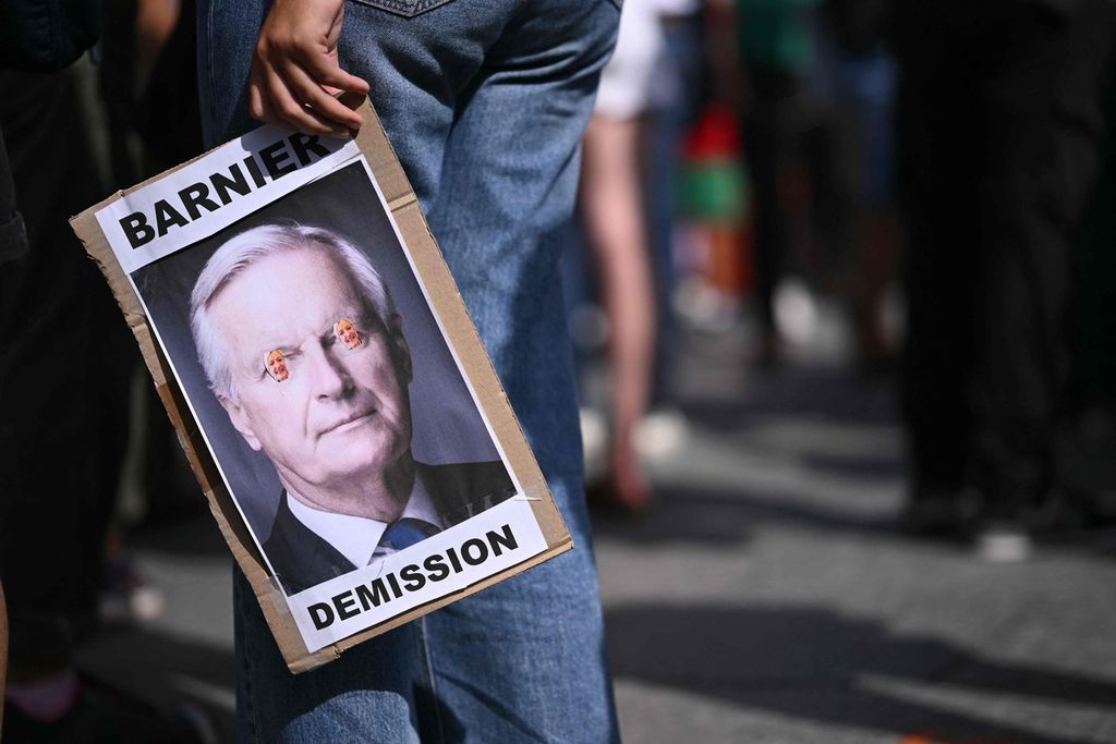 Pengunjuk rasa membawa foto Perdana Menteri Michel Barnier pada 7 September 2024 di Strasbourg, Perancis. Mereka menolak penunjukan Barnier sebagai PM Perancis.