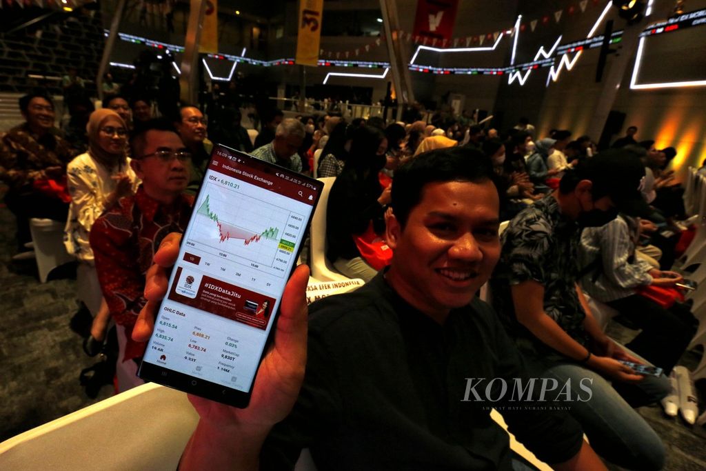 Tamu undangan menunjukkan aplikasi IDX Mobile saat diluncurkan di Gedung Bursa Efek Indonesia (BEI), Jakarta, Kamis (13/7/2023). 