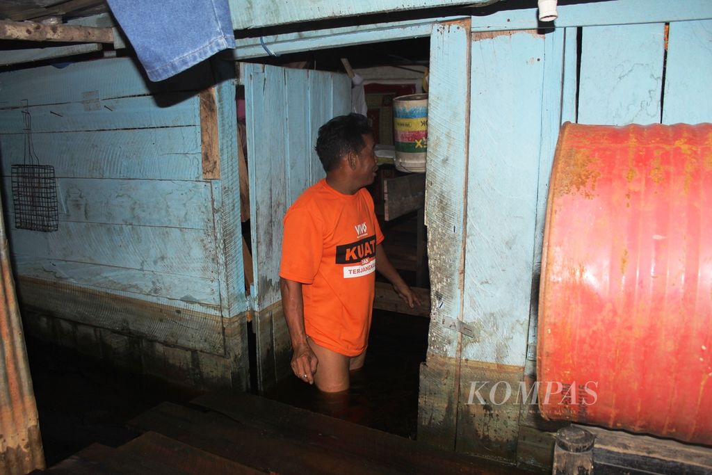 Burhan (43), warga Kelurahan Baru, Kalimantan Tengah, terendam di banjir yang menggenangi rumahnya pada Rabu (2/11/2022). 
