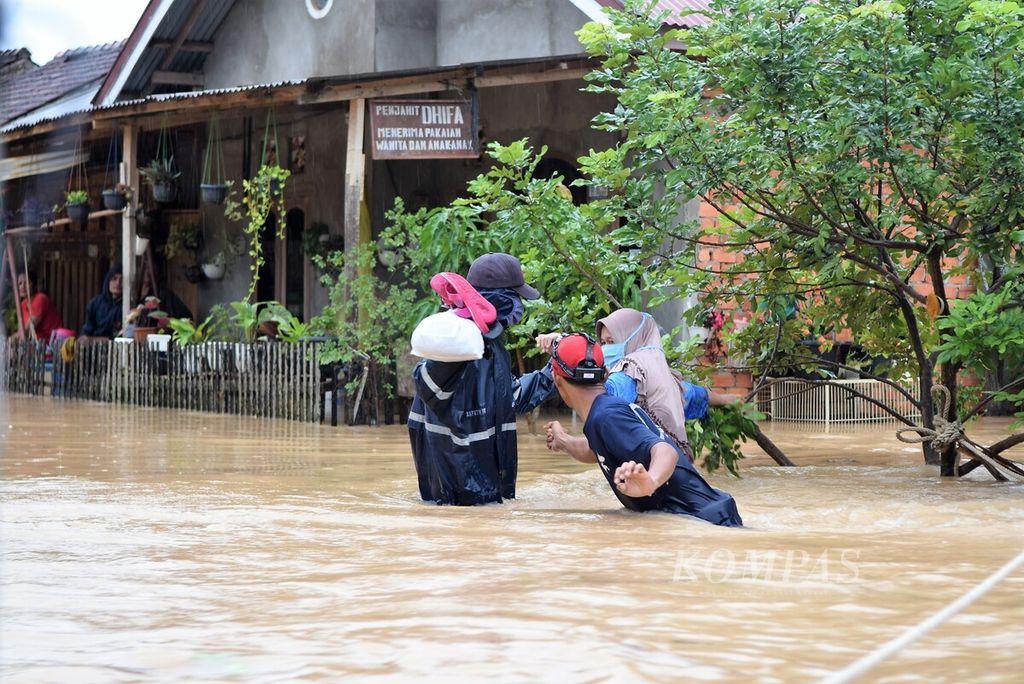Petugas dari Dinas Pemadam Kebakaran dan Penyelamatan Kota Jambi membantu evakuasi korban banjir di Perumahan Kembar Lestari II, Kota Jambi, Kamis (31/12/2020).