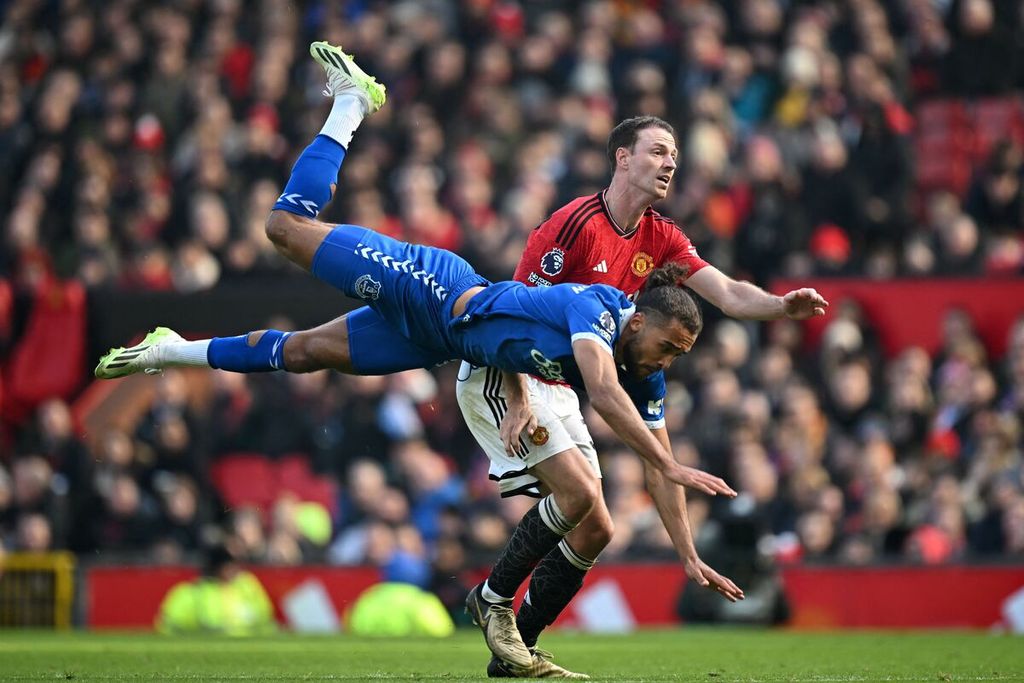 Everton's striker, Dominic Calvert-Lewin, is battling for the ball with Manchester United defender, Jonny Evans, in the English Premier League match between MU and Everton at Old Trafford Stadium on Saturday (9/3/2024). MU will visit Brentford's headquarters in the continuation of the English Premier League on Sunday (31/3/2024) early morning WIB.