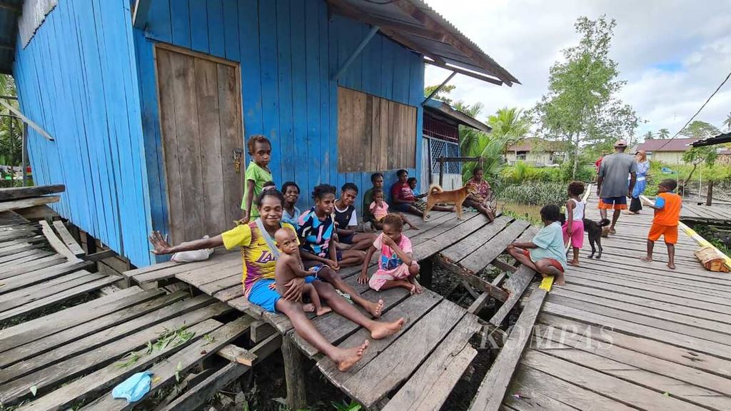 Sejumlah anak dan ibunya duduk santai di depan sebuah rumah dan jalan Kampung Akamar, Kampung Warse dan Birak di Kecamatan Jetsy, Kabupaten Asmat, Papua, Rabu (22/6/2022) siang.