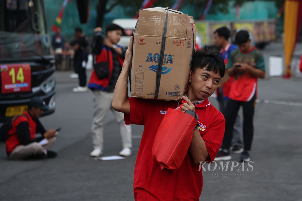 Peserta kegiatan mudik gratis untuk pedagang Warung Makan Indomie mendatangi titik kumpul di halaman Stadion Mandala Krida, Yogyakarta, Rabu (3/4/2024).