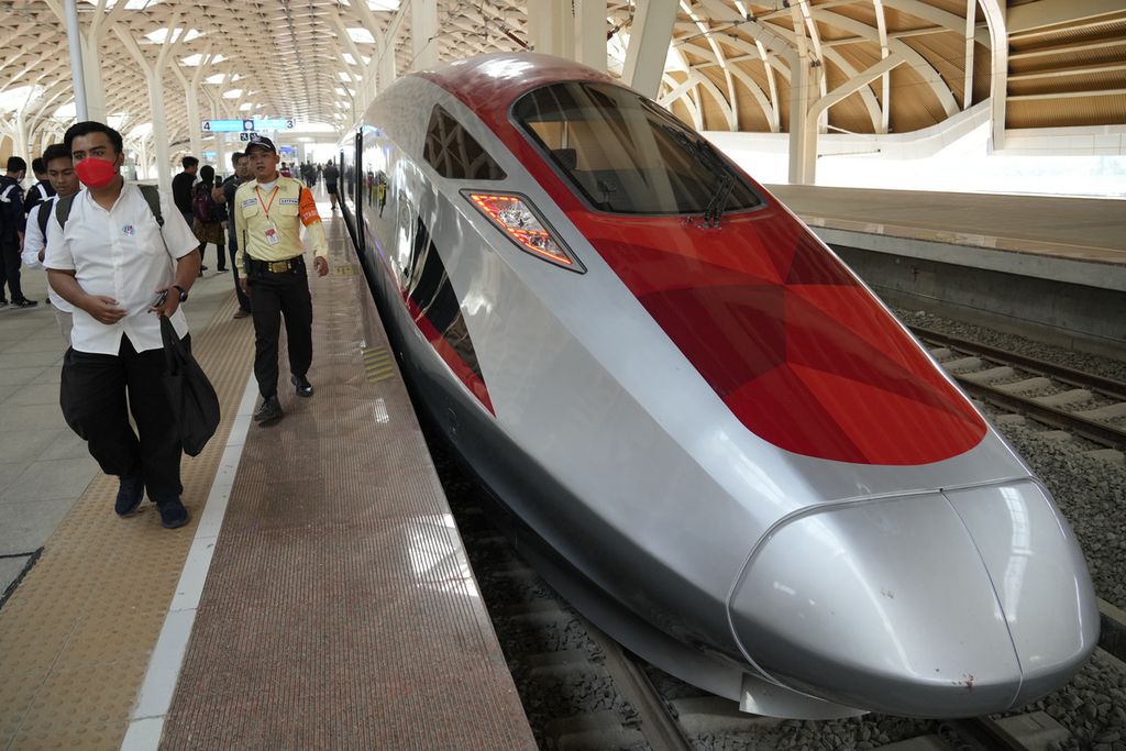Orang-orang berjalan di dekat kereta berkecepatan tinggi saat uji coba di stasiun Halim di Jakarta, Indonesia, pada 18 September 2023. 