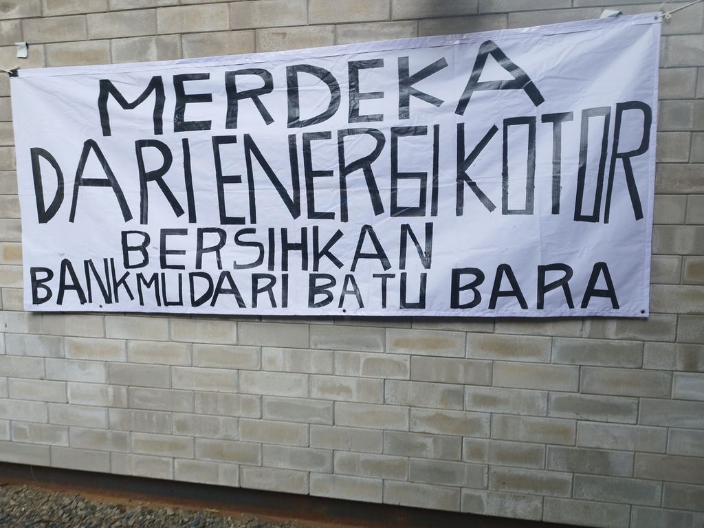 Spanduk yang menyuarakan kampanye untuk tidak lagi membiayai sektor batubara dalam diskusi ”Merdeka dari Energi Kotor, Bersihkan Bank-mu dari Batu-Bara”, di Jakarta, Rabu (13/4/2023).