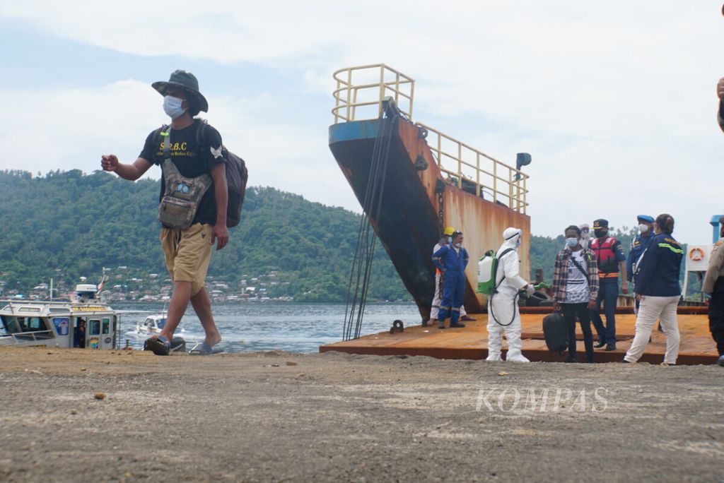 Seorang anak buah kapal berjalan menuju salah satu bus di dermaga Pelabuhan Samudera Bitung, Sulawesi Utara, setelah direpatriasi dari kapal-kapal perikanan China, Sabtu (7/11/2020). Para ABK itu terkatung-katung di laut sejak pandemi Covid-19 merebak.