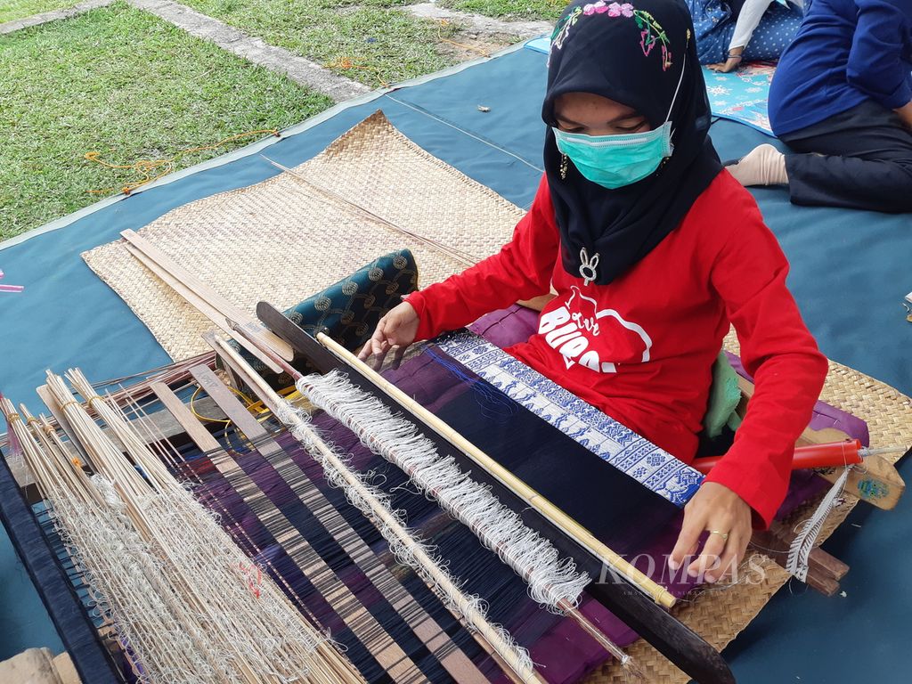 Seorang perajin songket sedang membuat songket di Desa Burai, Kecamatan Tanjung Batu, Kabupaten Ogan Ilir, Sumatera Selatan, Kamis (30/9/2021). Desa ini masuk dalam jajaran 50 Desa Wisata Terbaik di tahun 2021.