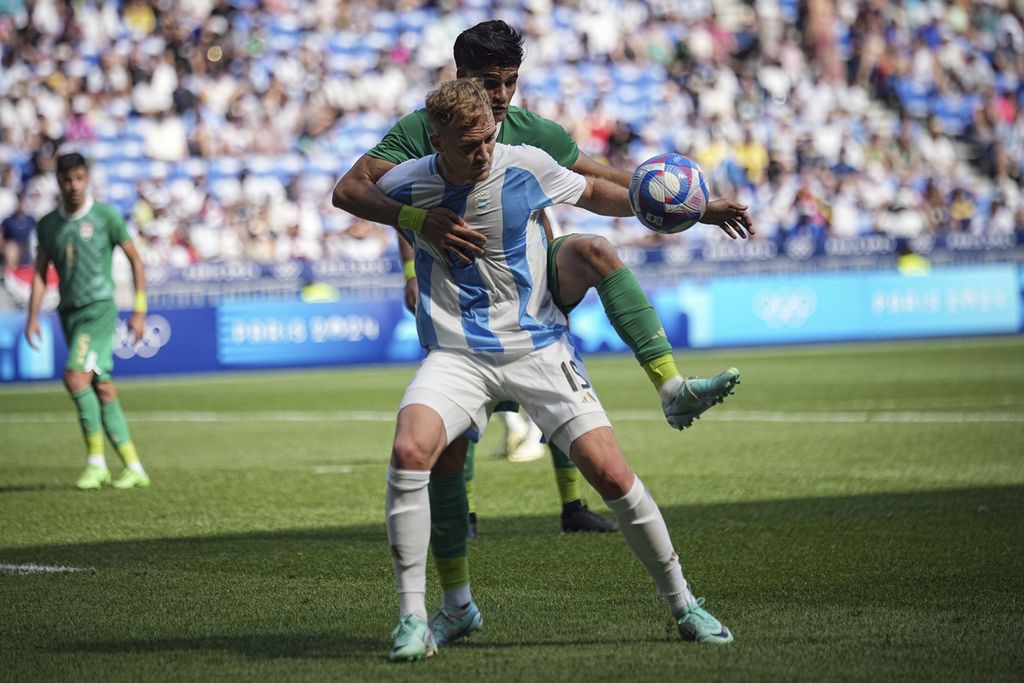 Pemain Argentina, Luciano Gondou, berebut bola dengan pemain Irak, Hussein Amer, dalam pertandingan Grup B sepak bola Olimpiade Paris 2024 antara Argentina dan Irak di Stadion Lyon, Decines, Perancis, Sabtu (27/7/2024). 