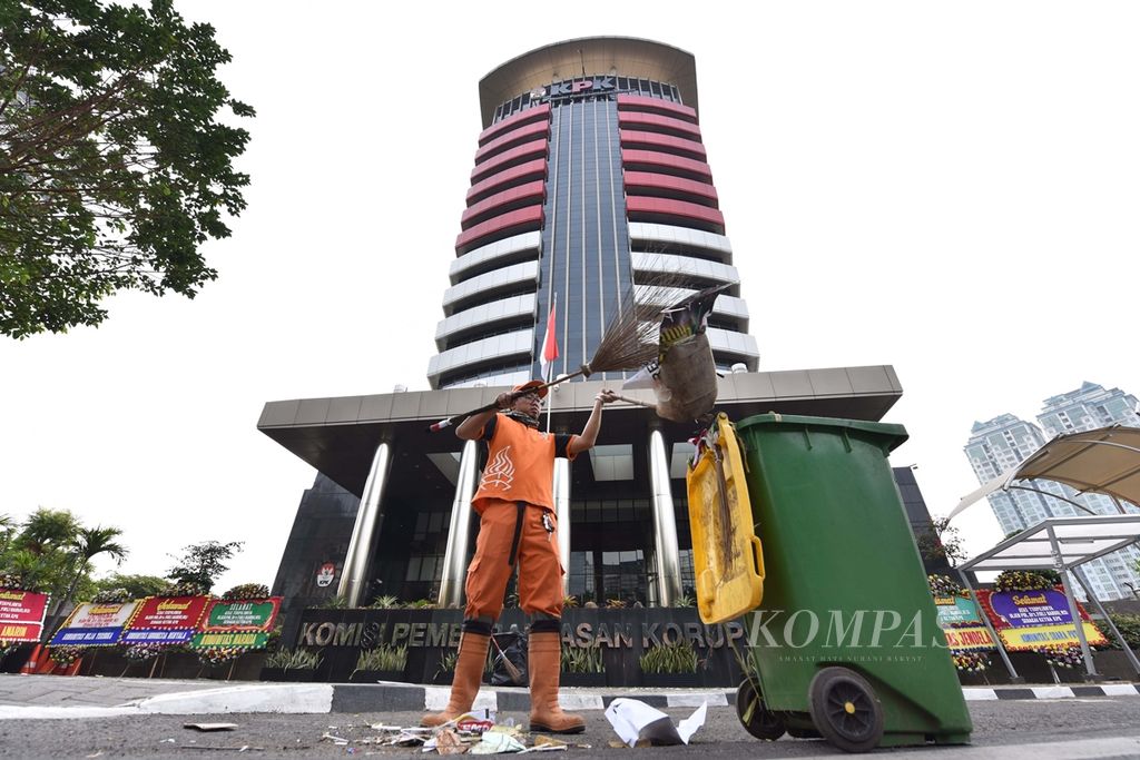 Petugas membersihkan sisa sampah yang ditinggalkan para demonstran pendukung revisi Undang-Undang Komisi Pemberantasan Korupsi di depan Gedung KPK, Kuningan, Jakarta, Minggu (15/9/2019).