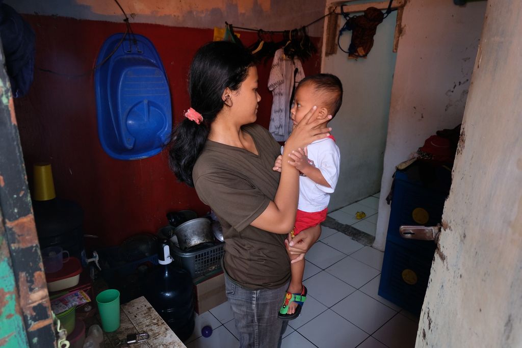 Nurjanah (16, kiri) menggendong anaknya yang berusia 15 bulan untuk melakukan pemeriksaan tinggi dan berat badan di rumahnya, Kelurahan Cakung Barat, Kecamatan Cakung, Jakarta Timur, Sabtu (8/4/2023). Anaknya didiagnosis mengalami <i>stunting</i> atau tengkes serta tuberkulosis (TBC). Nurjanah pun mengikuti program penanganan <i>stunting</i> di posyandu agar anaknya kembali sehat.