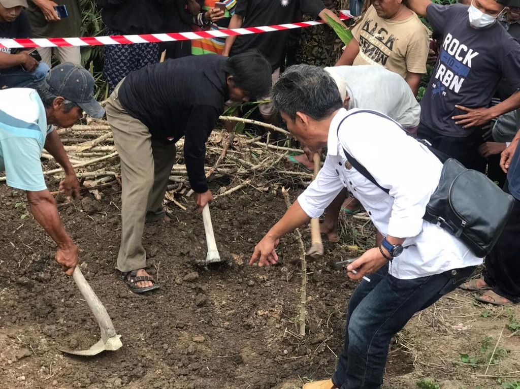 Warga bersama aparat desa menggali tanah yang diduga menjadi lokasi penguburan Juwanda (26), salah satu korban pembunuhan satu keluarga di Kabupaten Way Kanan, Lampung, Rabu (5/10/2022).