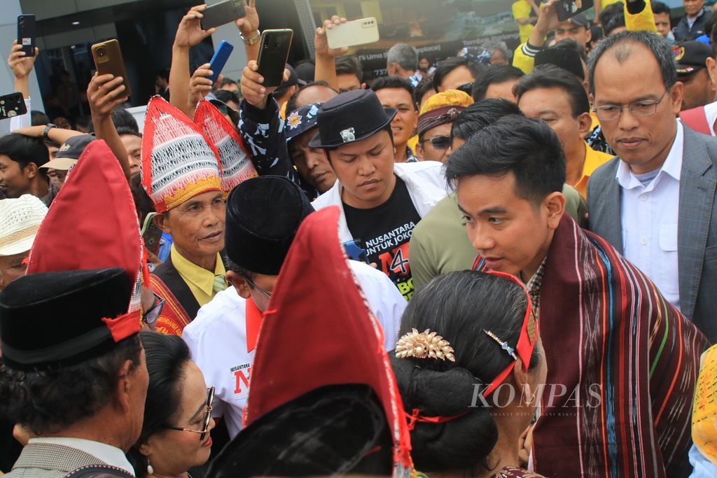 Calon wakil presiden Gibran Rakabuming Raka disambut dengan ulos saat tiba di Bandara International Silangit di Kabupaten Tapanuli Utara, Sumatera Utara, Sabtu (18/11/2023). 