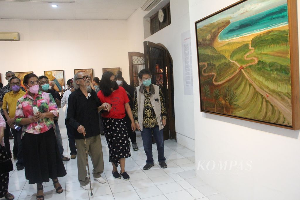Pelukis Djoko Pekik (kedua dari kiri) menunjukkan lukisannya kepada mantan Menteri Kelautan dan Perikanan Susi Pudjiastuti (paling kiri) dalam pembukaan pameran tunggal bertajuk Gelombang Masker, Sabtu (26/3/2022) malam, di Bentara Budaya Yogyakarta, Kota Yogyakarta. 