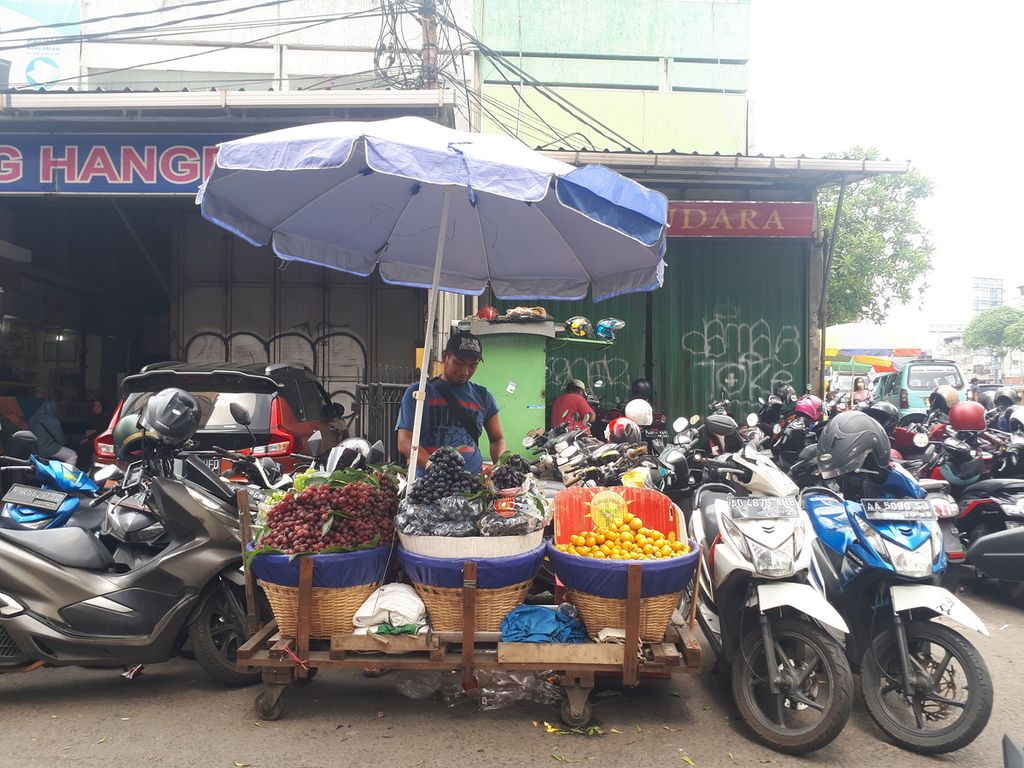 Pedagang buah Nur (36), tengah menjajakan buah-buahan yang dijualnya di Pasar Tanah Abang, Jakarta Pusat. Beberapa hari ini dia tengah mempersiapkan perjalanan mudik ke Kecamatan Karang Anyar, Kabupaten Demak, Jawa Tengah