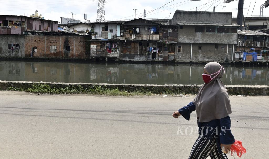 Warga berjalan kaki di permukiman padat penduduk di Pejagalan, Jakarta Utara, Senin (15/2/2021). 