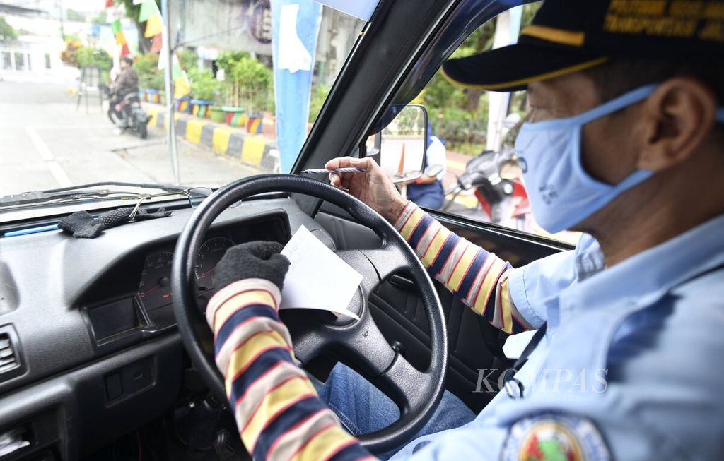 Pengemudi angkutan mikrotrans JakLingko mencatat kilometer perjalanan kendaraan di Terminal Grogol, Jakarta Barat, Sabtu (4/7/2020). Angkutan mikrotrans kembali beroperasi melayani penumpang umum setelah lebih dari tiga bulan tidak beroperasi sejak PSBB diberlakukan. Pada masa perpanjangan PSBB transisi, jumlah penumpang yang naik dibatasi dan diterapkan protokol kesehatan pencegahan penularan Covid-19.
