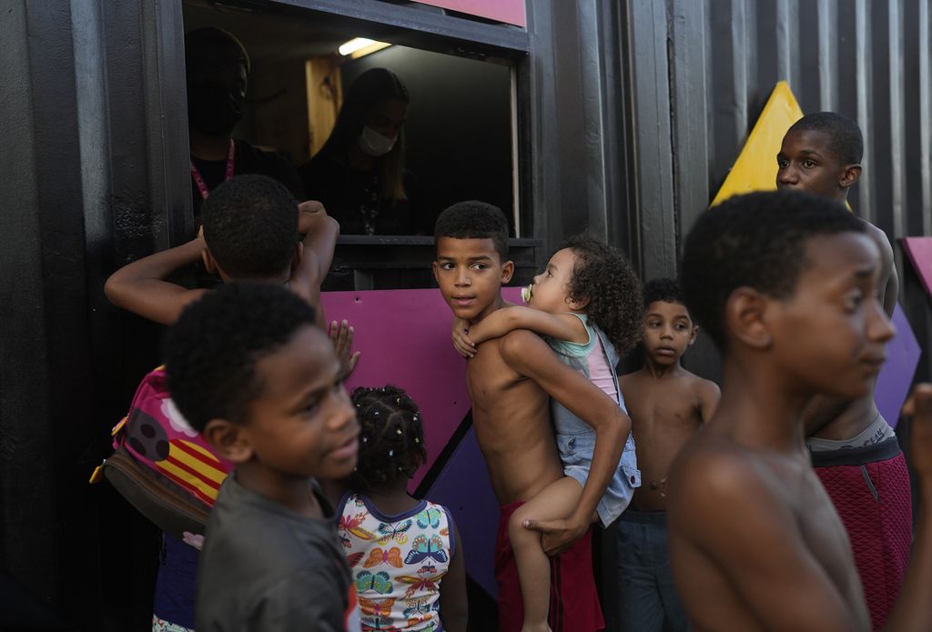 Anak-anak memperoleh tiket mononton film di &quot;Cinema no Morro&quot; di pusat kebudayaan di <i>favela </i>Vila Cruzeiro, Rio de Janeiro, Brasil, 13 September 2021. 