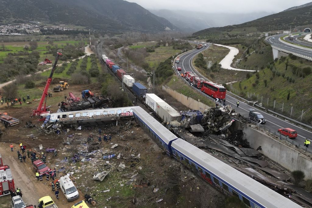 Tim penyelamat berikut peralatan di lokasi tabrakan maut antara kereta penumpang dan kereta barang di Tempe, dekat Kota Larissa, Yunani, Rabu (1/3/2023). Puluhan penumpang tewas dalam kejadian itu. 